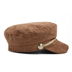 Detailed view of brown corduroy fiddler cap with golden rope and embossed buttons