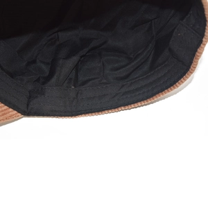Detail view of brown corduroy newsboy cap with black fabric lining and clean stitching