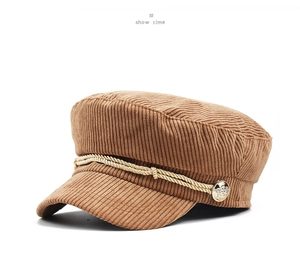 Detail of brown corduroy octagonal hat with gold braided rope and vintage metal button