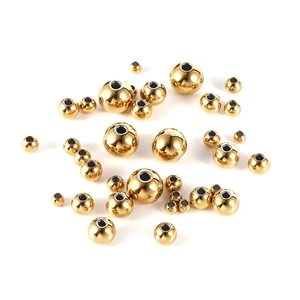 Macro view of assorted golden stainless steel beads for DIY jewelry making and crafts