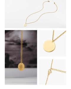 Detailed view of sunburst coin pendant and adjustable lobster clasp on gold necklace