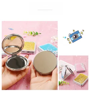 Detail view of double-sided folding mirrors with sparkling quicksand and metal frames