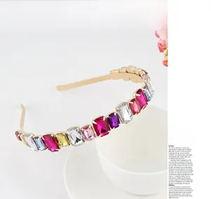Detail of gold metal headband with colorful rectangular crystals over a white ceramic cup