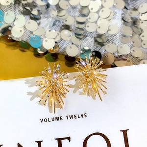 Golden firework stud earrings with sparkling cubic zirconia on a minimalist background