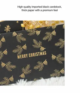 Detail of premium black cardstock with gold foil Christmas pine patterns and festive text
