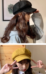 Detail view of stylish black and yellow suede newsboy caps worn by a fashion model