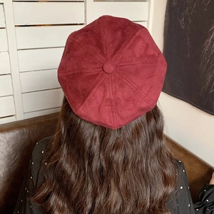 Detail view of burgundy suede beret hat with button top and vintage 8-panel stitch design