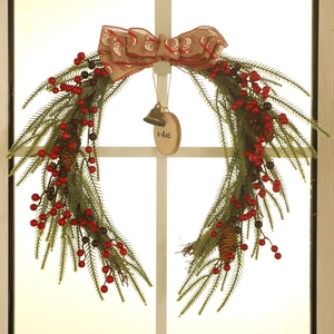 Detail of Christmas wreath with burlap bow, red berries, bell and X-MAS wood tag