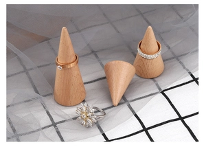 Detailed view of cone wooden ring holders with sparkling diamond rings on mesh fabric