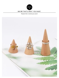 Close-up of three rings on wooden cone displays featuring floral and crystal designs