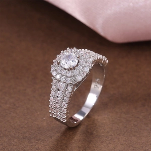 Detail of 925 sterling silver ring with halo setting and triple-row side diamonds