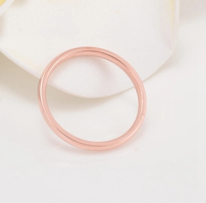 Polished rose gold minimalist thin band ring displayed on white flower petals