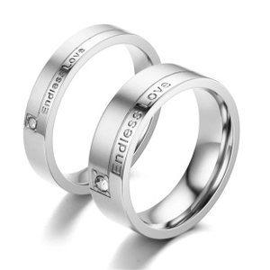 Detail view of silver titanium steel couple rings with Endless Love engraving and small diamond