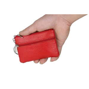 Red genuine leather coin purse with lychee texture and metal keychain in hand