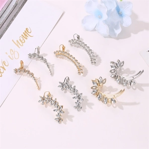 Detail of silver and gold crystal stud earrings with shiny rhinestone floral designs