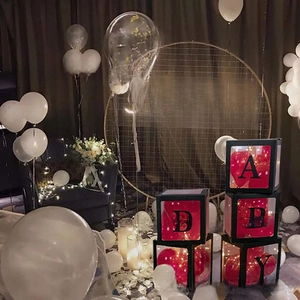 Close-up of BABY letter boxes with red balloons and LED lights for party decor