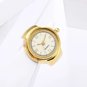 Close-up of golden quartz ring watch with Roman numeral dial on a minimalist pedestal
