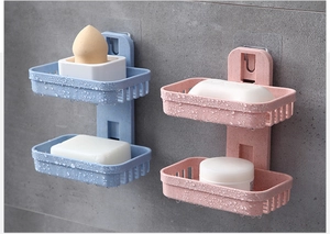 Detail of dual-layer wheat straw soap holder with drainage holes on a tiled wall