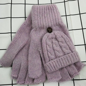 Détail de gants tricotés violets avec motif torsadé et bouton en bois sur le rabat