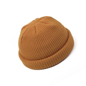 Detailed view of the ribbed knit texture and ginger yellow fabric of the retro beanie hat