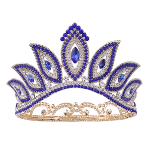 Detailed macro shot of baroque gold crown with blue crystals and sparkling rhinestones