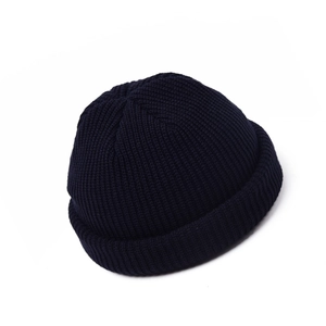 Detail view of navy knit docker cap with thick ribbed texture and rolled cuff edge