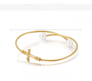 Detailed specs of gold steel wire bracelet with shell pearls and cross charm