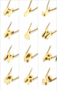 Detail view of 3D gold-plated heart initial pendants with box chain on white background