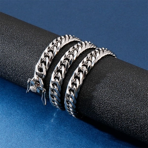 Polished silver titanium steel Cuban link bracelet set for men on a dark blue background