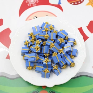 Blue miniature Christmas gift boxes with gold ribbons displayed on a decorative plate
