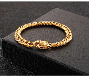 Macro shot of an 18K gold-plated chunky Cuban link necklace on a black textured jewelry box