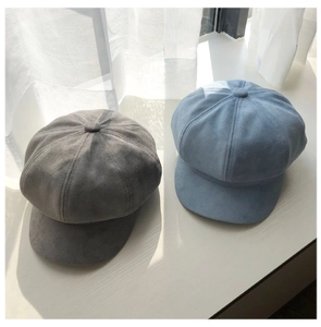 Detail view of grey and light blue suede newsboy caps with fine stitching texture
