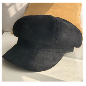Detail of black faux suede newsboy cap featuring matte texture on a white surface
