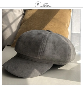 Detailed texture of gray suede newsboy cap featuring multi-panel stitching and soft finish