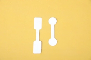 Close-up of white jewelry price tags for rings and necklaces on a yellow background