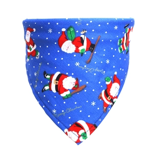 Close-up of blue cotton Christmas dog bandana with skiing Santa and golden text