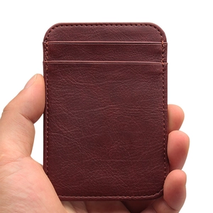 Vertical slim brown leather card holder with multiple slots shown in hand on white background