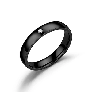 Bague minimaliste en acier titane noir avec un seul diamant sur fond blanc pur
