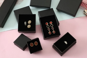 Detailed view of assorted black pearl-pattern jewelry boxes for rings and earrings