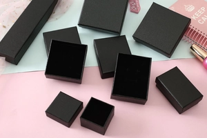 Macro view of assorted black jewelry boxes with lychee grain texture and velvet lining