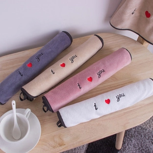 Four colorful coral fleece towels with I love you embroidery neatly arranged on a wooden table