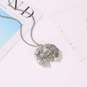 Détail du collier tournesol ouvrant avec gravure You Are My Sunshine à l'intérieur