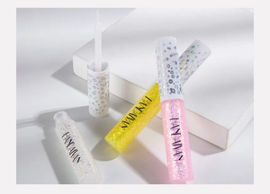 Detailed shot of pink, yellow, and white liquid glitter eyeliners with fine brush applicator