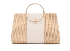 Detail of beige straw weave texture and circular gold metal handle on evening handbag