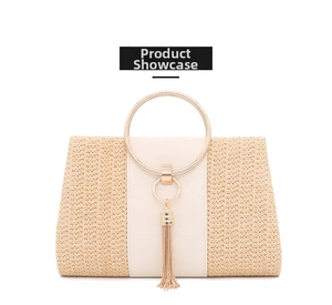 Detail of woven straw handbag with white faux leather panel and gold ring handle