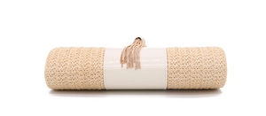 Detail of woven straw evening bag with smooth cream material and gold chain tassel