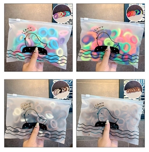 Dettaglio di elastici per capelli senza cuciture in vari colori e pochette opaca con zip
