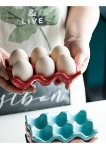 Detail of 6-grid ceramic egg tray in red, blue and pink for stylish kitchen storage