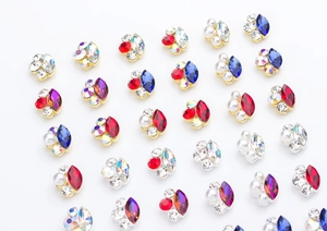 Macro shot of assorted color K9 crystal nail charms in cat paw shape with metal frames