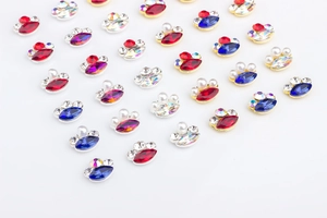Macro view of marquise-shaped nail art crystals with gold and silver metal borders